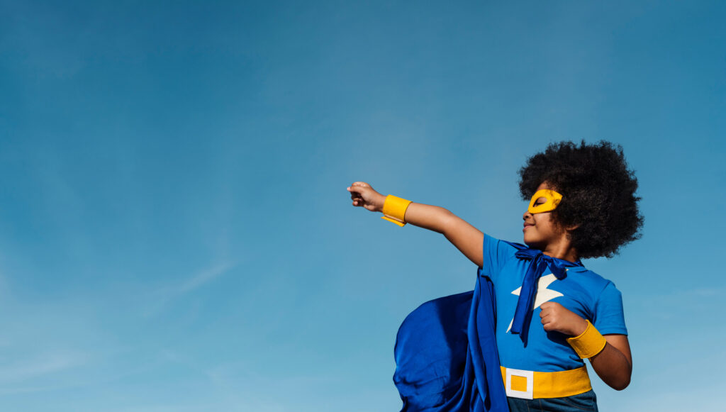 Child in a superhero costume with arm raised to the side.