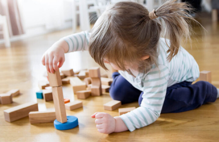 Young girl playing with building blocks.