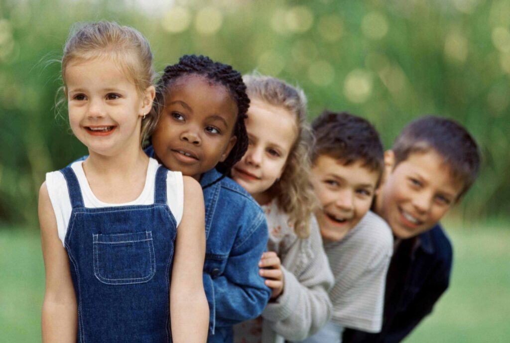 Children standing in a line and smiling.